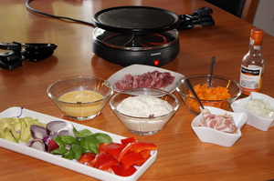 Alle de forskellige dele klar til at komme på racletten. På billede er der også forberedt æggekage med bacon og løg